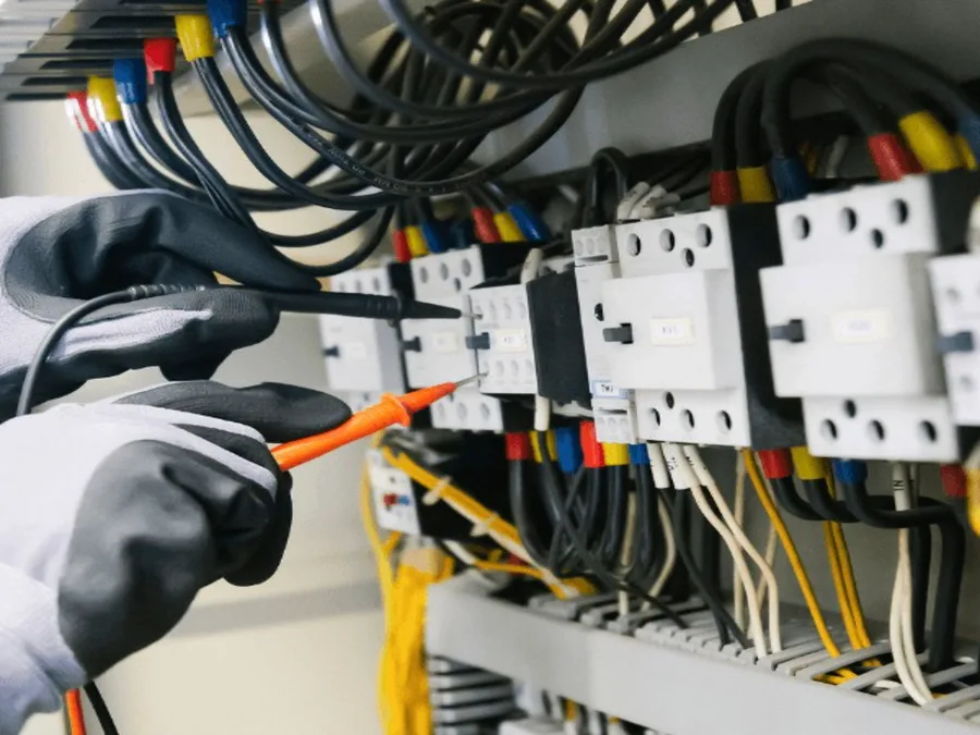 Técnica dando mantenimiento a un tablero eléctrico